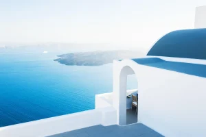Santorini white blue house on caldera overlooking the sea below